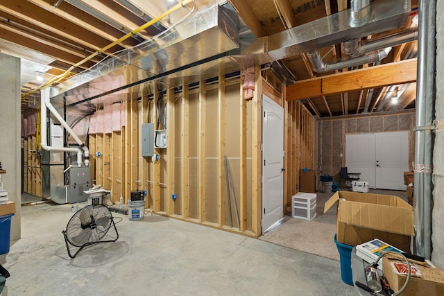 basement featuring electric panel and heating unit