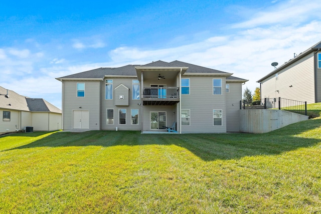 rear view of property with a yard, ceiling fan, a balcony, and central AC unit