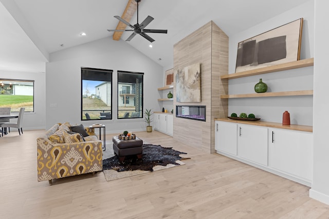 living area featuring high vaulted ceiling, baseboards, light wood-style floors, beamed ceiling, and a tiled fireplace