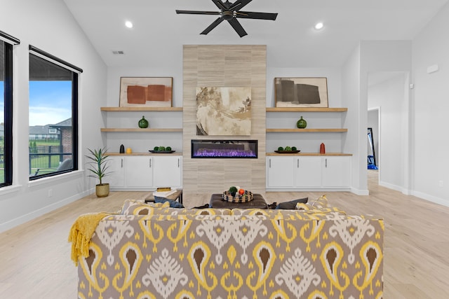 living room featuring recessed lighting, built in shelves, baseboards, and a tile fireplace