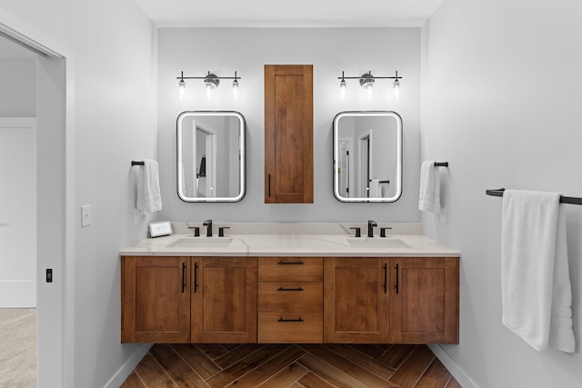 bathroom featuring a sink, baseboards, and double vanity