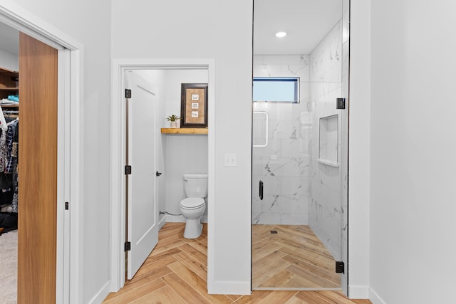 full bath with baseboards, toilet, and a marble finish shower