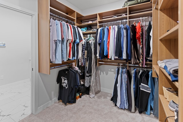 walk in closet featuring marble finish floor and carpet flooring