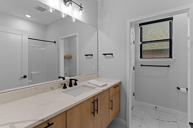 full bath featuring vanity, visible vents, baseboards, marble finish floor, and a shower