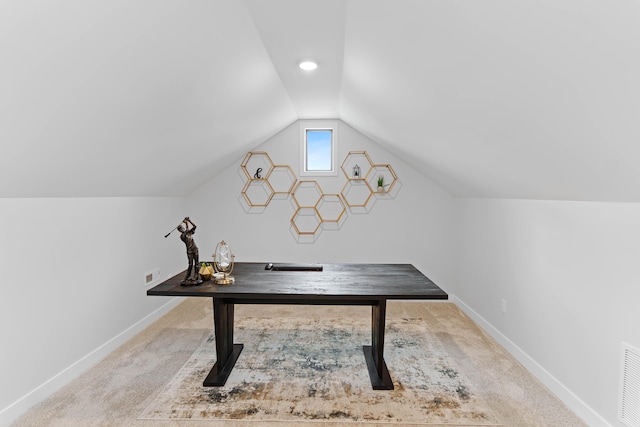 carpeted office space featuring lofted ceiling and baseboards