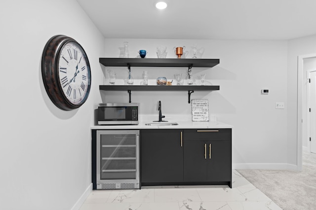 bar with marble finish floor, stainless steel microwave, a sink, wet bar, and beverage cooler