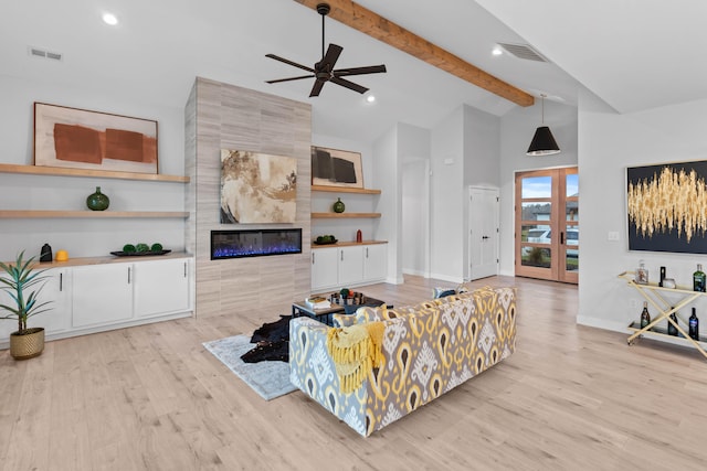 living area with light wood-style flooring, a fireplace, visible vents, and beamed ceiling