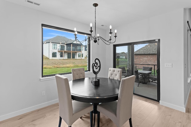 dining space with light wood finished floors, baseboards, and visible vents