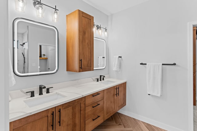 bathroom featuring double vanity, a sink, and baseboards