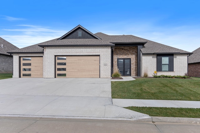 prairie-style home featuring a garage and a front lawn