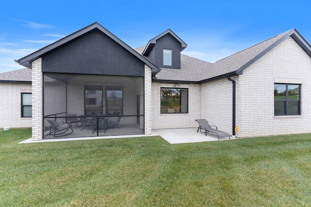 rear view of property with a yard, a patio, brick siding, and a shingled roof