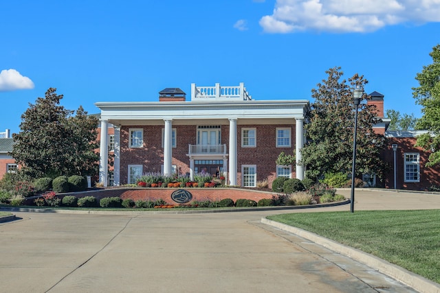 view of front facade with brick siding and a front yard