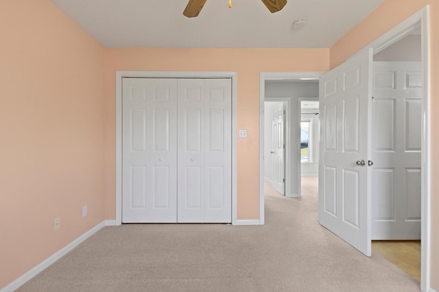 unfurnished bedroom featuring light carpet, a closet, and baseboards