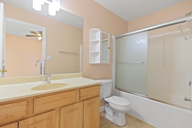 bathroom featuring vanity, a ceiling fan, bath / shower combo with glass door, tile patterned floors, and toilet