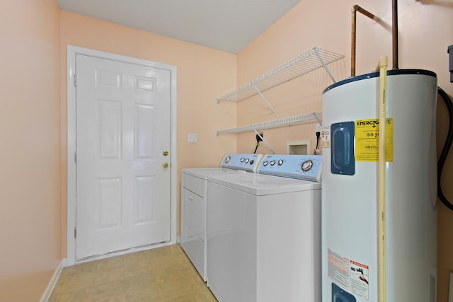 laundry area with washer and clothes dryer, baseboards, laundry area, and electric water heater