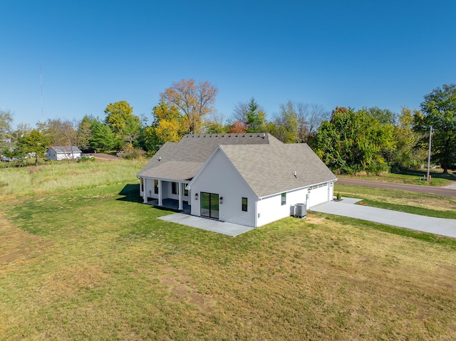 back of house with central AC and a lawn