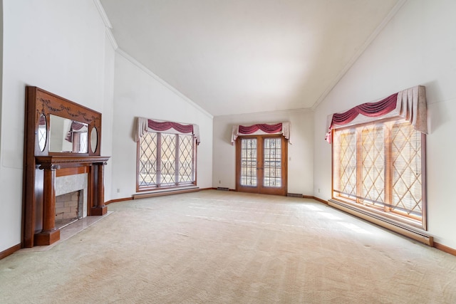 unfurnished living room with crown molding, high vaulted ceiling, a high end fireplace, light colored carpet, and french doors