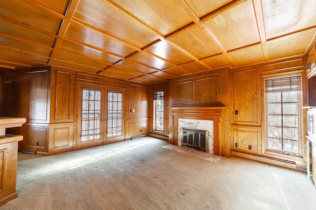 unfurnished living room featuring coffered ceiling, a high end fireplace, wooden ceiling, and french doors