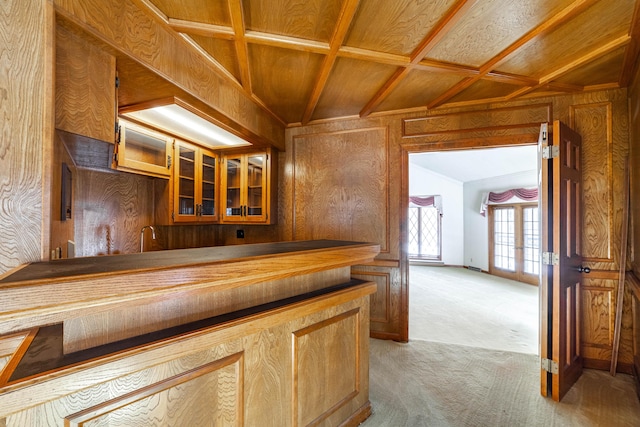 kitchen featuring coffered ceiling, wooden walls, carpet, and wooden ceiling