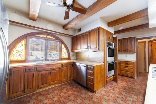 kitchen featuring tasteful backsplash, sink, beamed ceiling, and appliances with stainless steel finishes