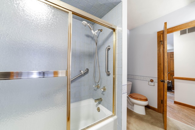 bathroom with enclosed tub / shower combo and toilet