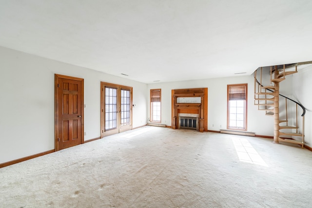 unfurnished living room featuring carpet, baseboard heating, and french doors