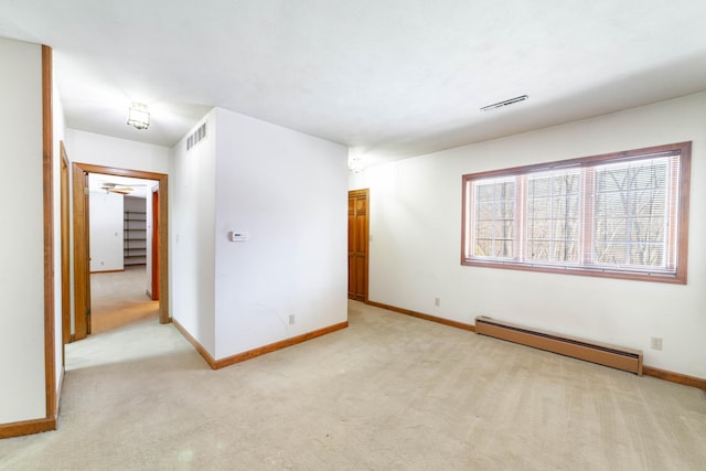 carpeted spare room with a baseboard heating unit