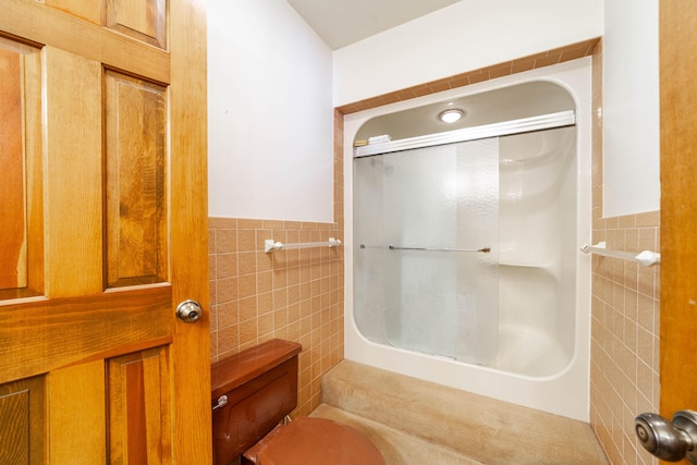 bathroom featuring tile walls, toilet, and walk in shower