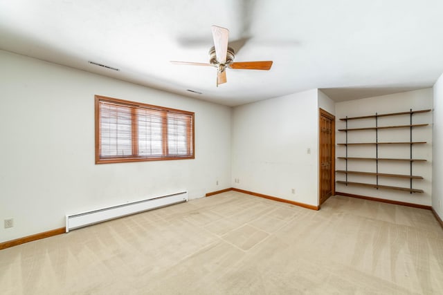 empty room featuring carpet floors, a baseboard heating unit, and ceiling fan