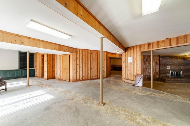 basement with a fireplace and wooden walls