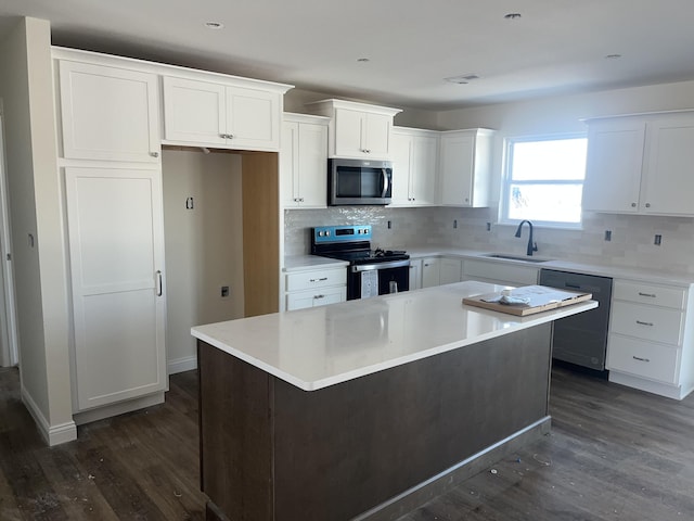 kitchen featuring white cabinetry, appliances with stainless steel finishes, a center island, and sink