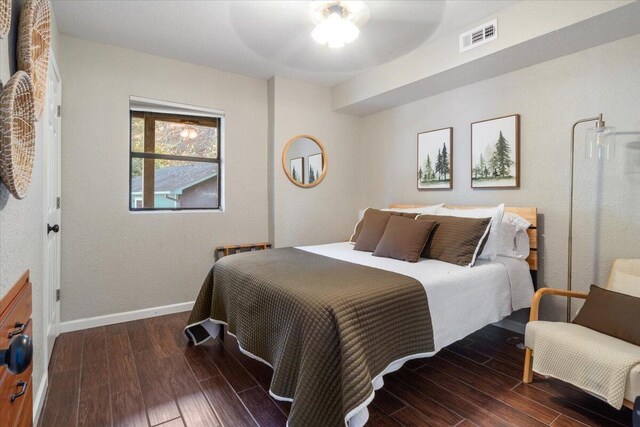 bedroom with dark hardwood / wood-style floors and ceiling fan