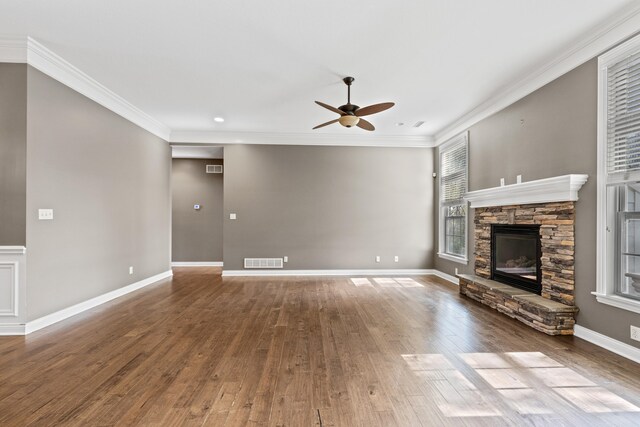 unfurnished living room with hardwood / wood-style floors, a fireplace, ceiling fan, and ornamental molding