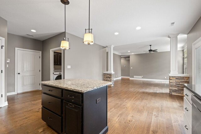 kitchen with ceiling fan, decorative light fixtures, hardwood / wood-style floors, a center island, and ornate columns