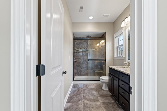 bathroom featuring toilet, an enclosed shower, and vanity