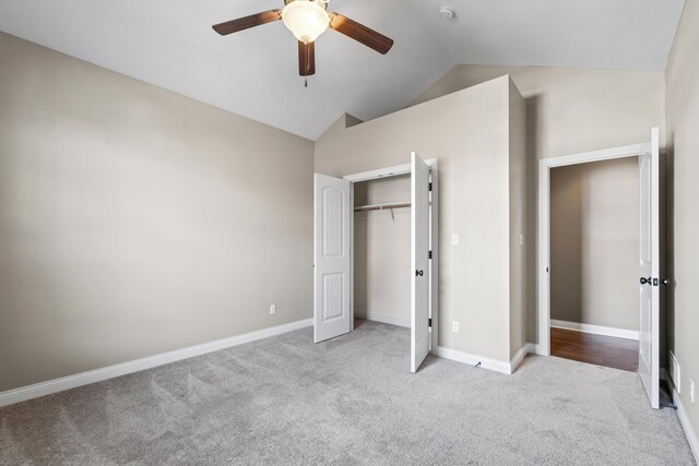 unfurnished bedroom with a closet, vaulted ceiling, light carpet, and ceiling fan