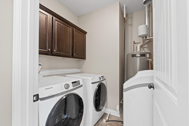 laundry room featuring water heater, cabinets, and washing machine and clothes dryer