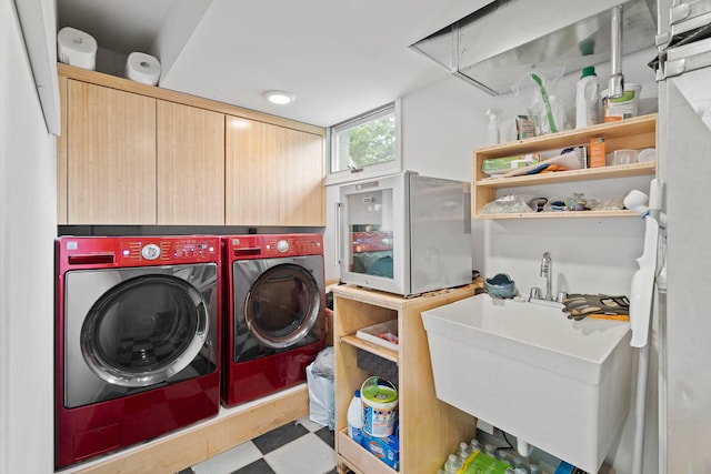 laundry room with sink, washer and dryer, and cabinets