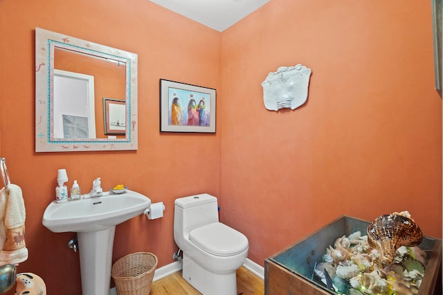 bathroom featuring sink, wood-type flooring, and toilet