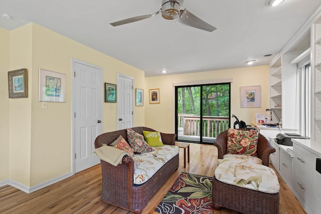 living room with light wood-type flooring and ceiling fan