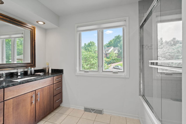 bathroom with vanity, enclosed tub / shower combo, and tile patterned flooring