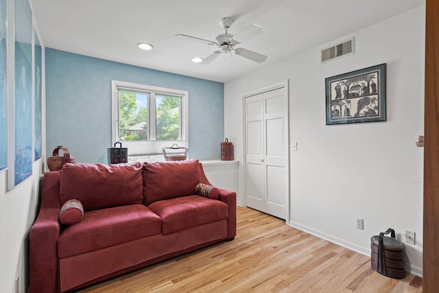 living room with light hardwood / wood-style floors and ceiling fan