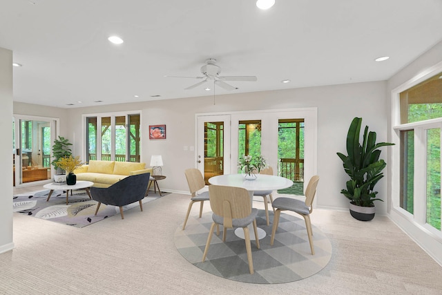 dining room featuring a healthy amount of sunlight, light colored carpet, and ceiling fan