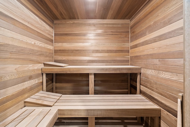 view of sauna / steam room featuring wood ceiling and wooden walls