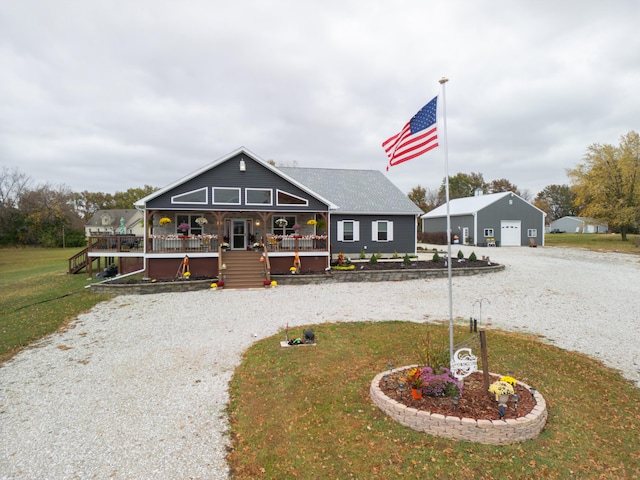 farmhouse-style home with a garage, an outdoor structure, a front yard, and covered porch