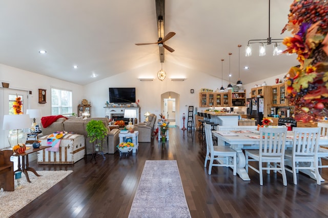 dining space with ceiling fan, vaulted ceiling, and dark hardwood / wood-style floors