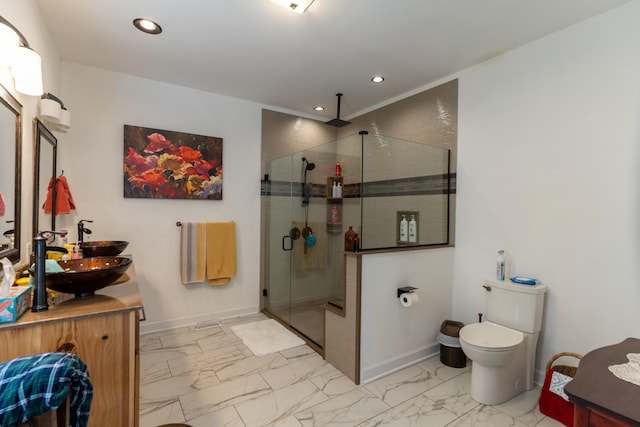 bathroom with vanity, toilet, and a shower with door