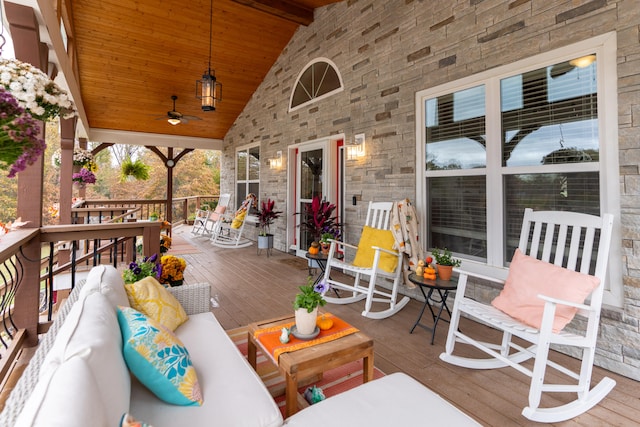 wooden deck with an outdoor living space and ceiling fan