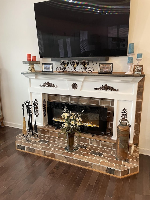 room details with a tiled fireplace and hardwood / wood-style floors