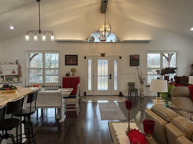 living room with dark wood-type flooring, a wealth of natural light, and a notable chandelier